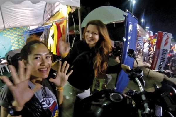 a couple of women waving at night