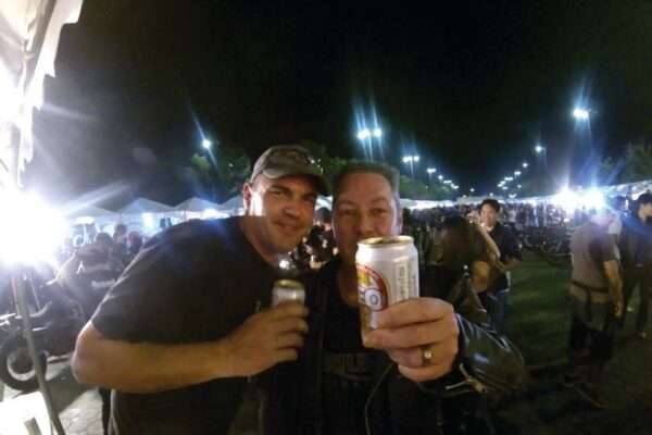 two men holding cans and smiling at the camera