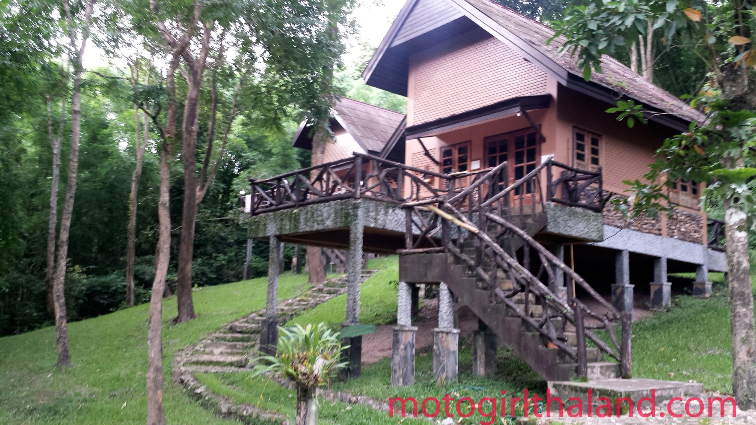 a wooden house on stilts in a grassy forest. Chae Son National Park