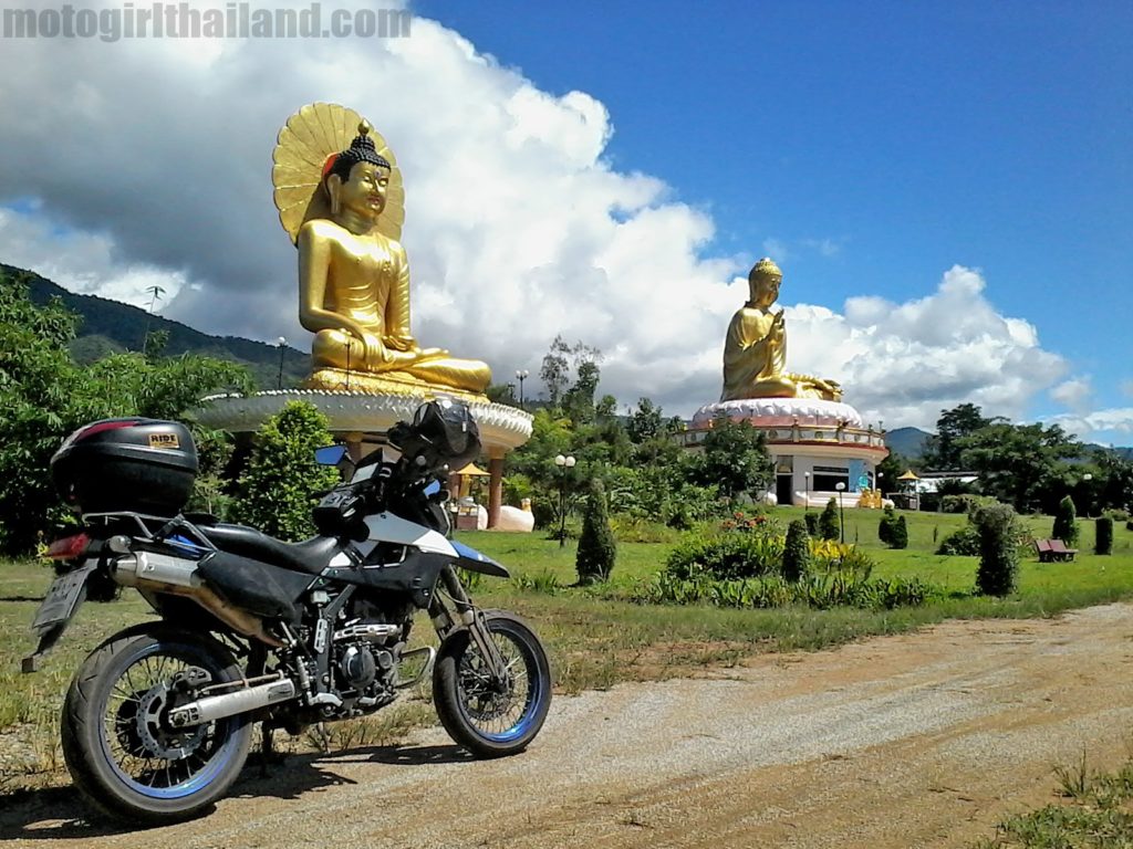 A motorcycle and giant gold Buddha statues. Thailand. motogirlthailand