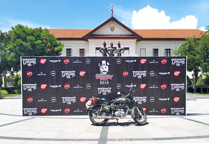 a Royal Enfield motorcycle parked in front of a sign. Distinguished Gentleman's Ride. Chiang Mai, Thailand.