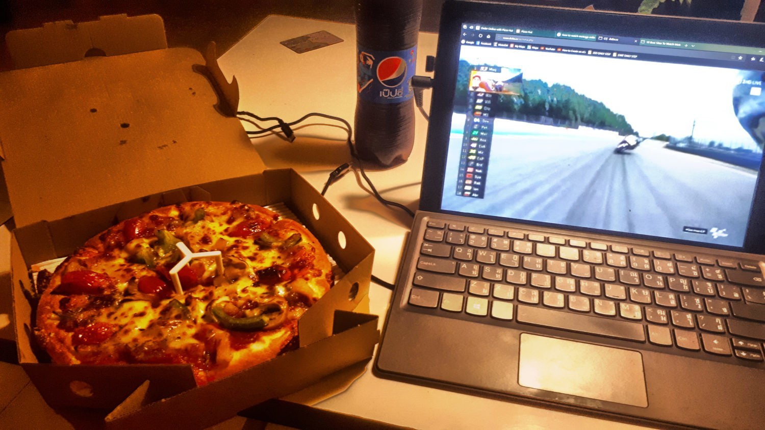 Pizza in a box and MotoGP on a laptop. Pizza Company, Thailand