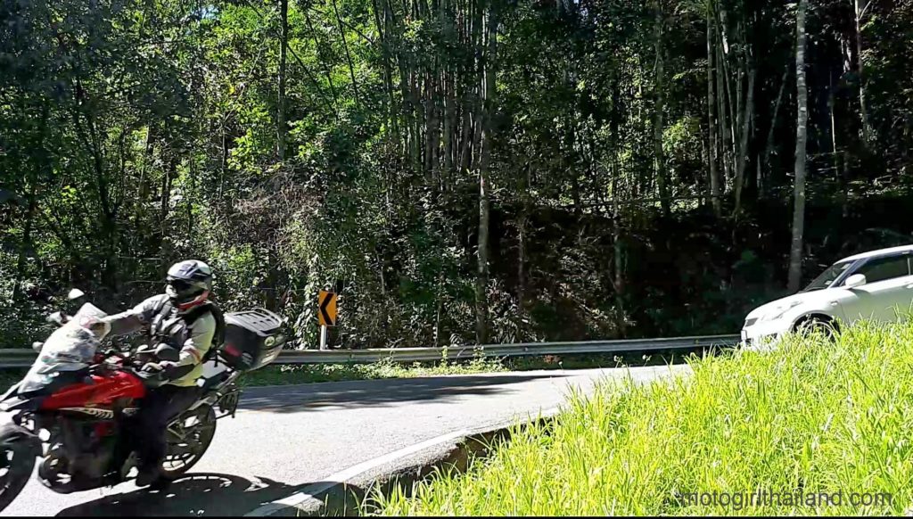 a motorcycle and car on a twisty road