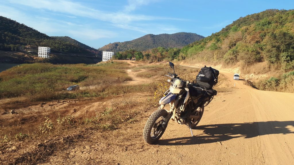 motorbike, dirt road and suspension Bridge Mae Khuang Dam