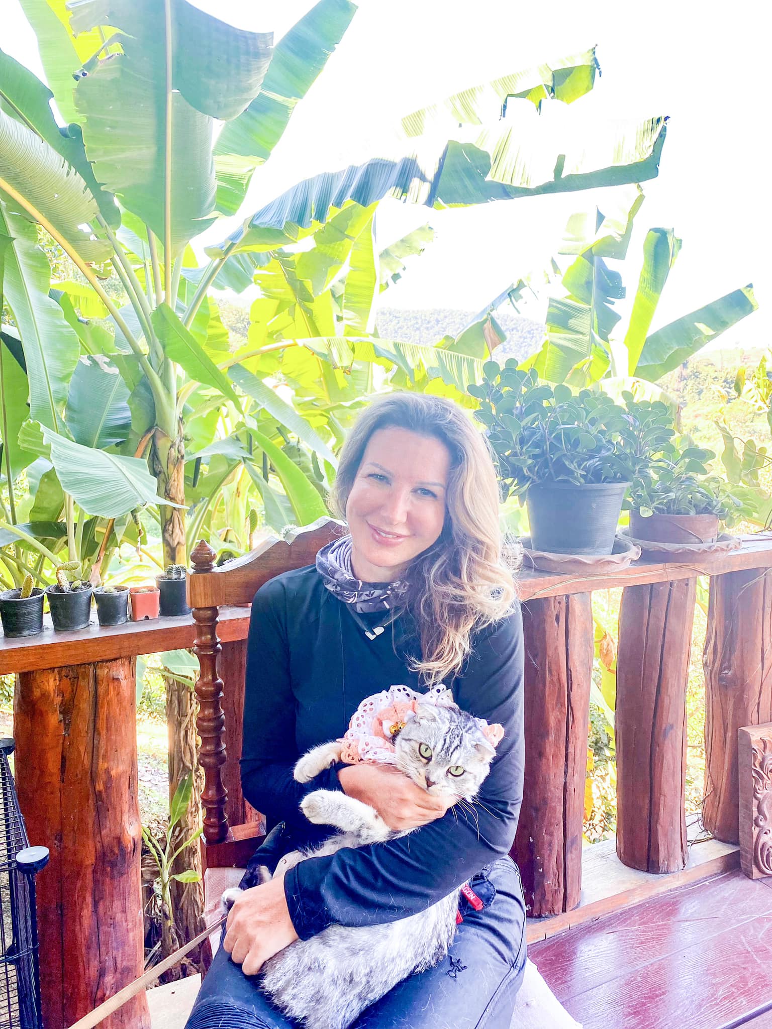 lady smiling holding a Scottish Fold cat.