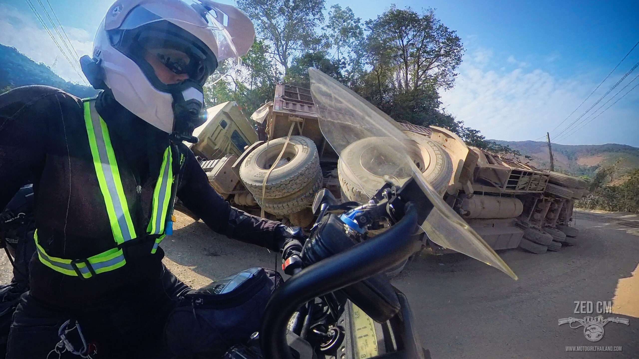 fallen truck and motorcycle rider in laos